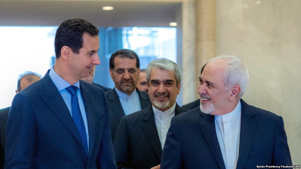 Syrian President Bashar Assad, left, speaks with Iranian Foreign Minister Mohammad Javad Zarif, right, in Damascus, April 16, 2019