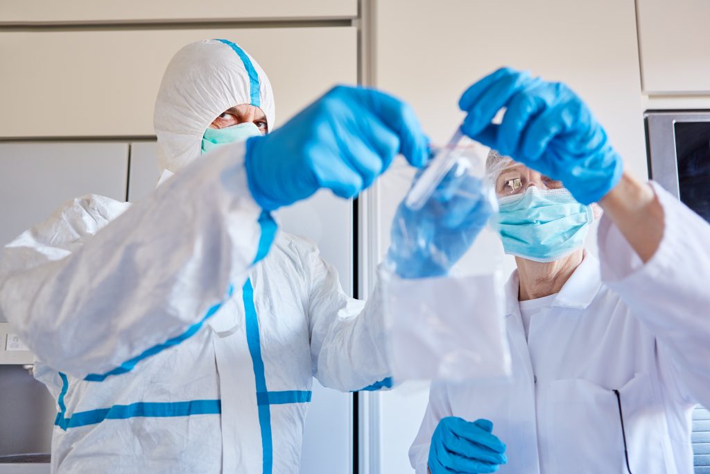 Saliva sample for Covid-19 test goes to the laboratory by employees in protective clothing