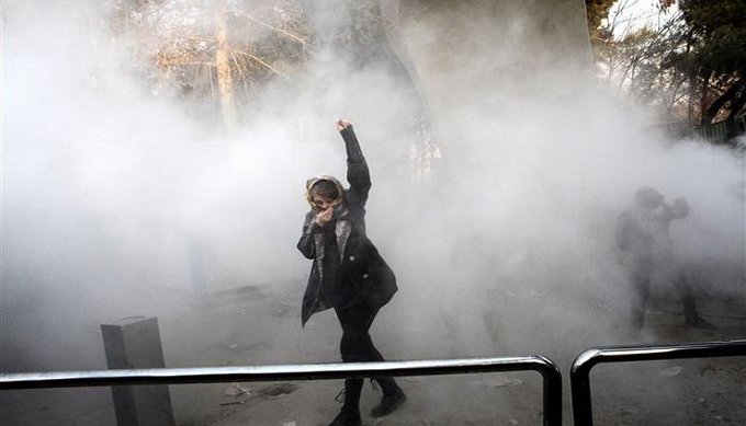 متظاهرة إيرانية وسط دخان قنابل الغاز- أرشيفية