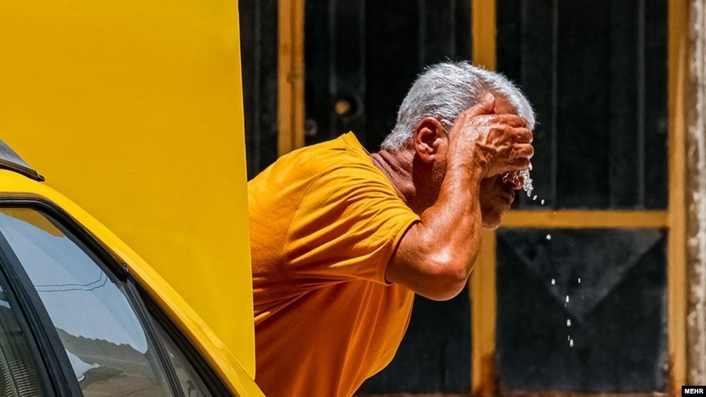 אדם שוטף את פניו בחום העז של עבאדן