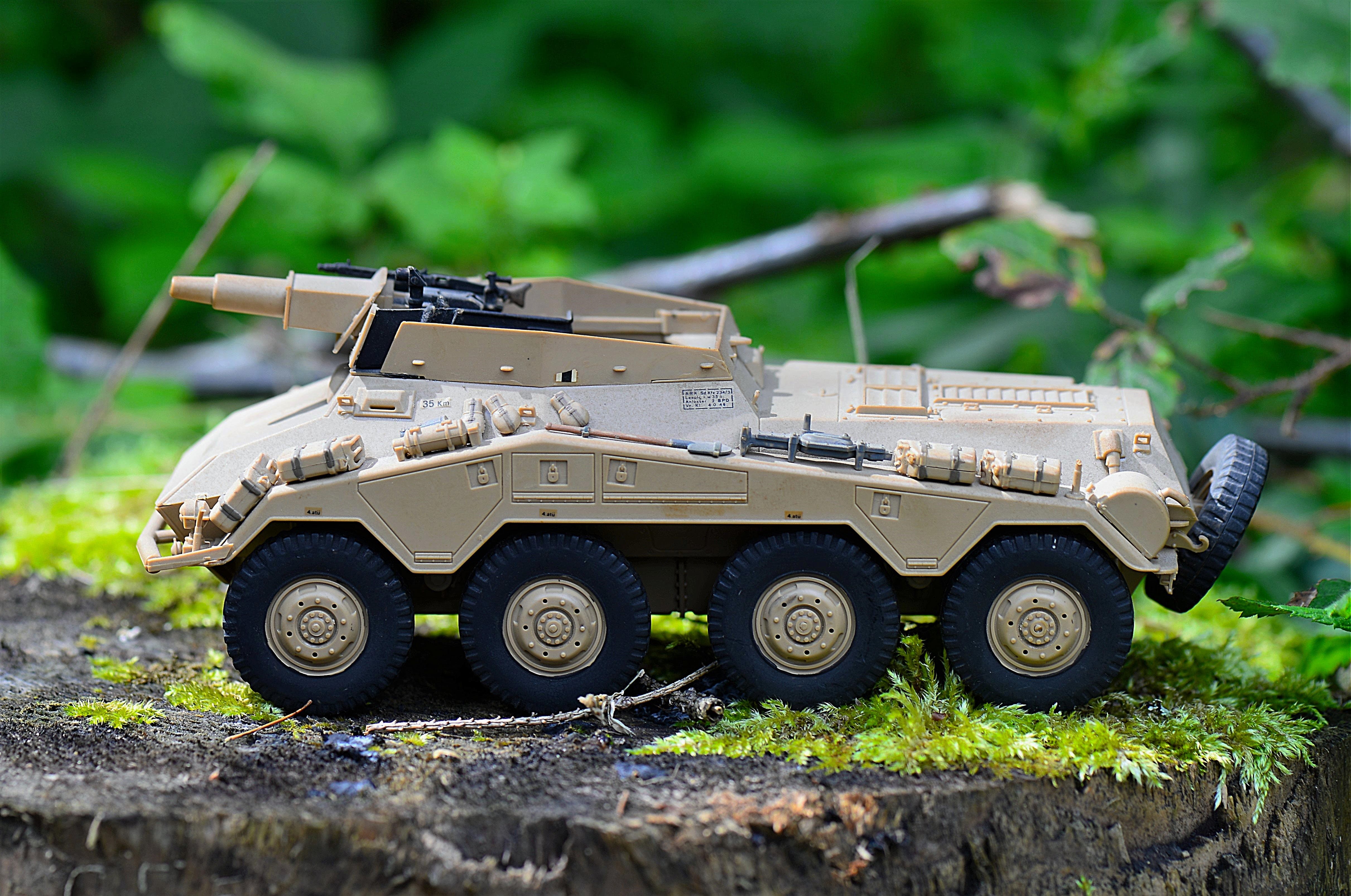 Free Tan Military Artillery Vehicle Toy on Wood Stump Stock Photo